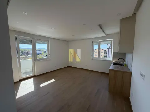Spacious bright living room with laminate flooring, access to the terrace, and a small kitchenette area. - image 2