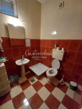 Tiled bathroom with a washbasin and a toilet. - image 11