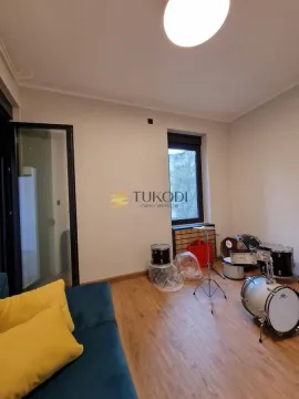 Empty room with wooden flooring, a sofa and a drum kit. - image 13