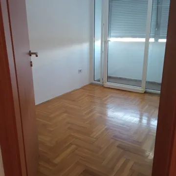 Empty room with parquet flooring and balcony access. - image 3