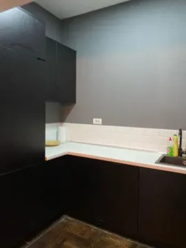 Moderna kuhinja sa crnim elementima i bijelim pločicama. - image 5
