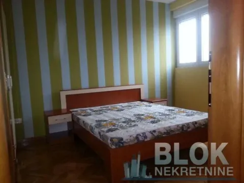 Bedroom with a double bed, nightstands, and striped wallpaper. - image 4