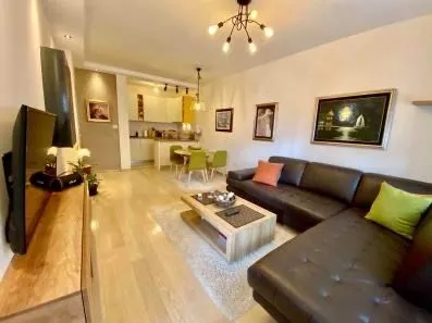 Living room with sofa and view towards the dining area and kitchen.