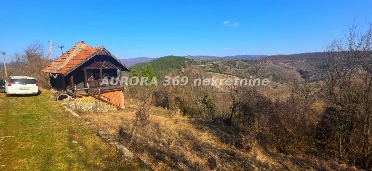Pogled na manju kuću sa placem i prirodom u okruženju.