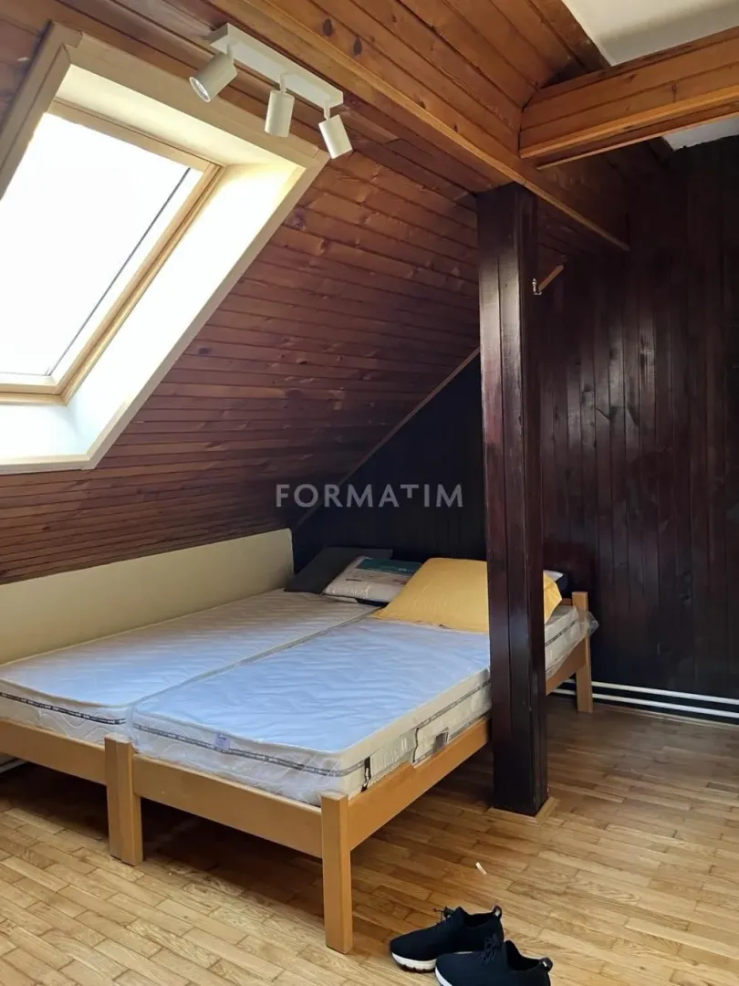 Attic bedroom furnished with a bed and a skylight.