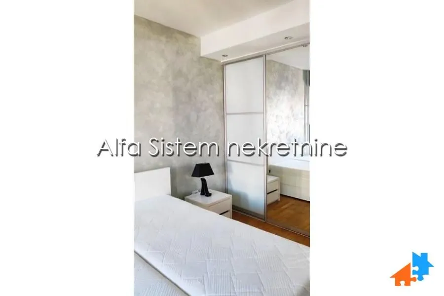 Bedroom with a bed and a built-in mirrored wardrobe.