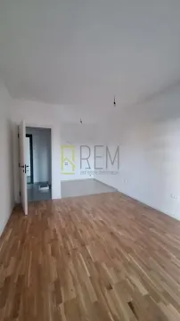 Prazna soba sa drvenim podom i vodenim žigom agencije. - image 3