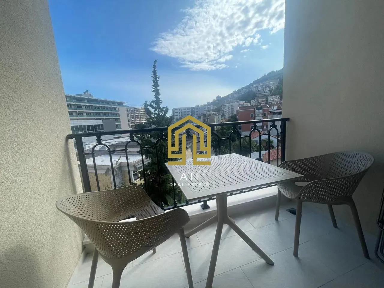 Furnished terrace with a table, chairs, and a city view.