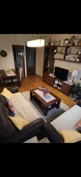 Furnished living room with a sofa set, television, and dining area. - image 3