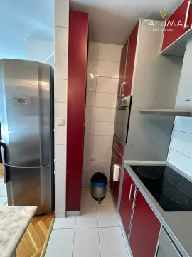 Kitchen equipped with red cabinets and built-in appliances. - image 4