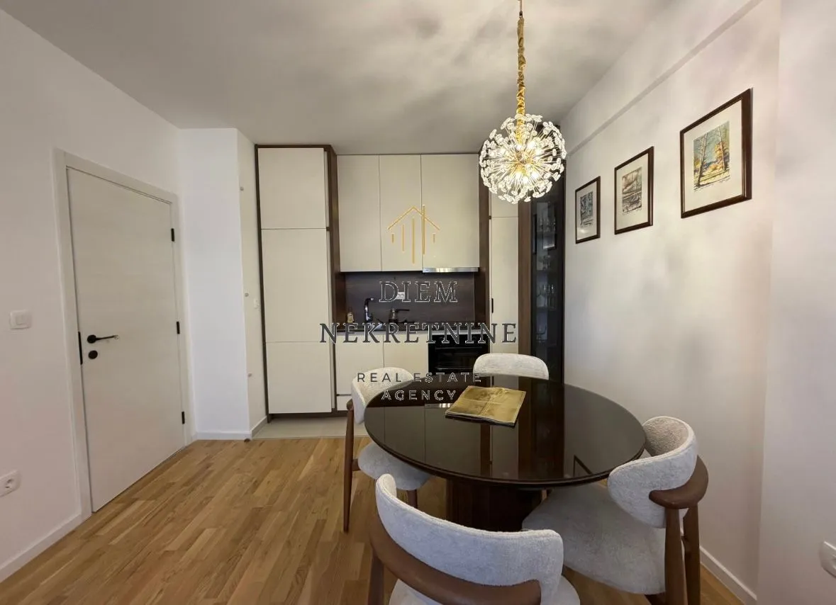 Dining area with a modern table and chairs, connected to the kitchen.
