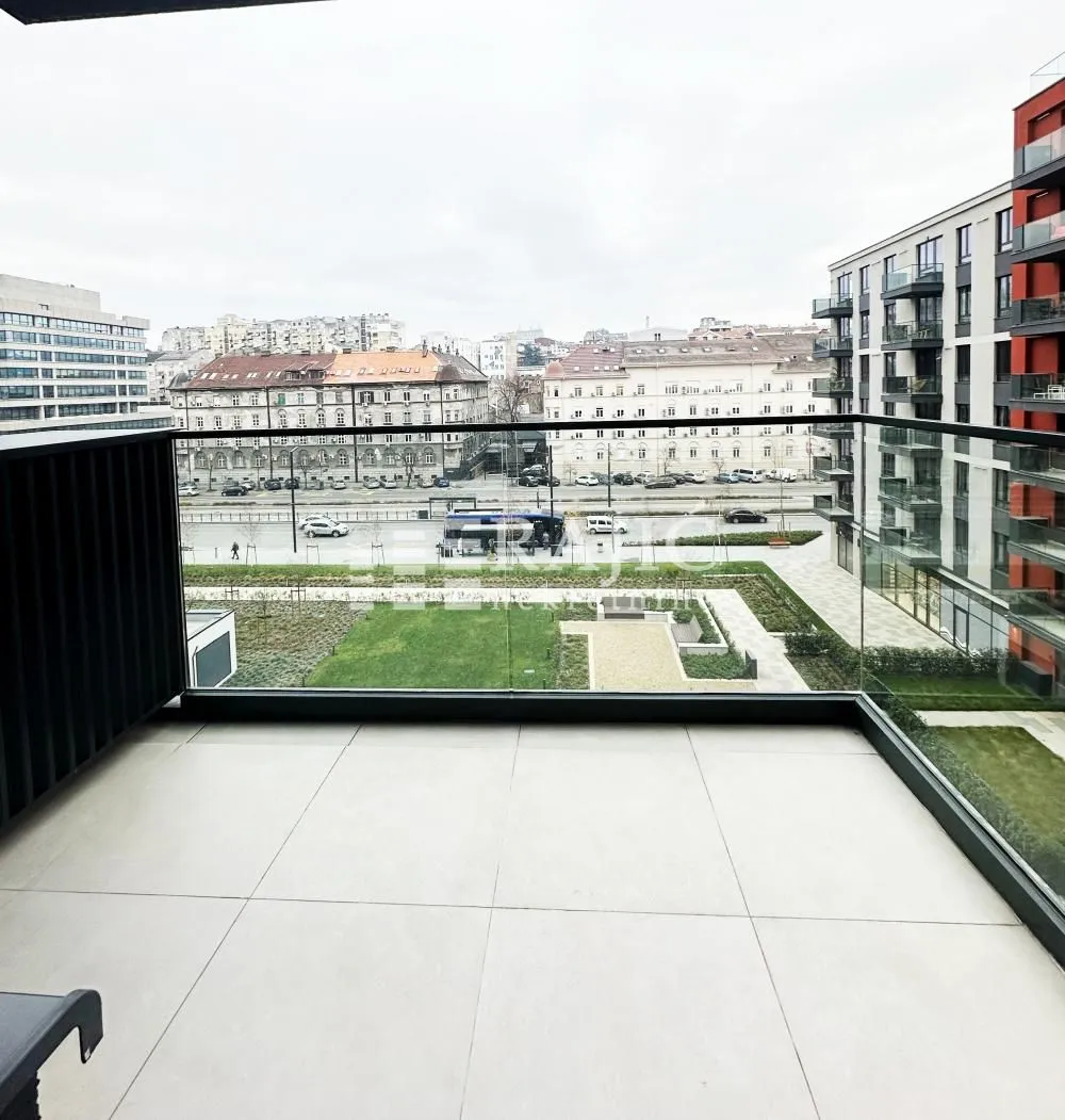 Modern tiled balcony with glass railing and city view.