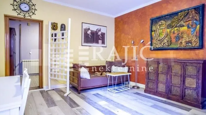Living room with a sofa, chest of drawers, and art paintings on the wall.