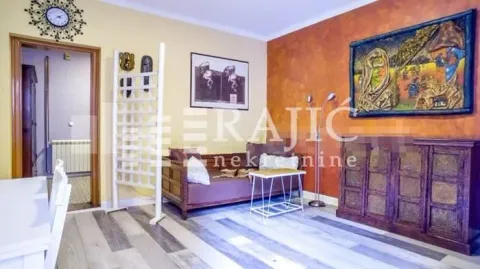 Living room with a sofa, chest of drawers, and art paintings on the wall. - image 16