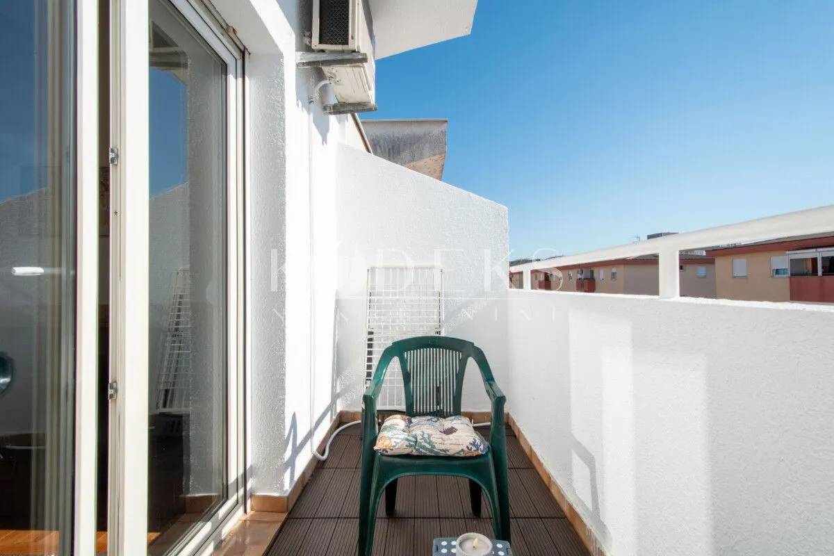 Balkon sa staklenim kliznim vratima i stolicom.