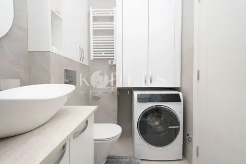 Moderne kupatilo sa bijelim elementima, umivaonikom i veš mašinom. - image 4
