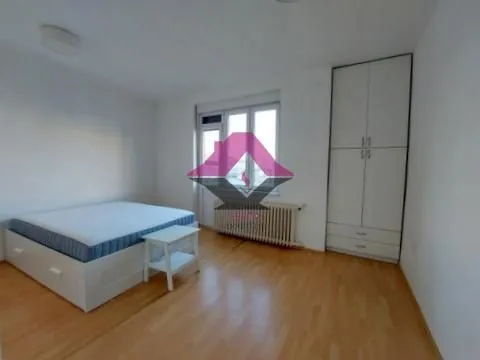 Bedroom with a double bed, white wardrobe, and a window.