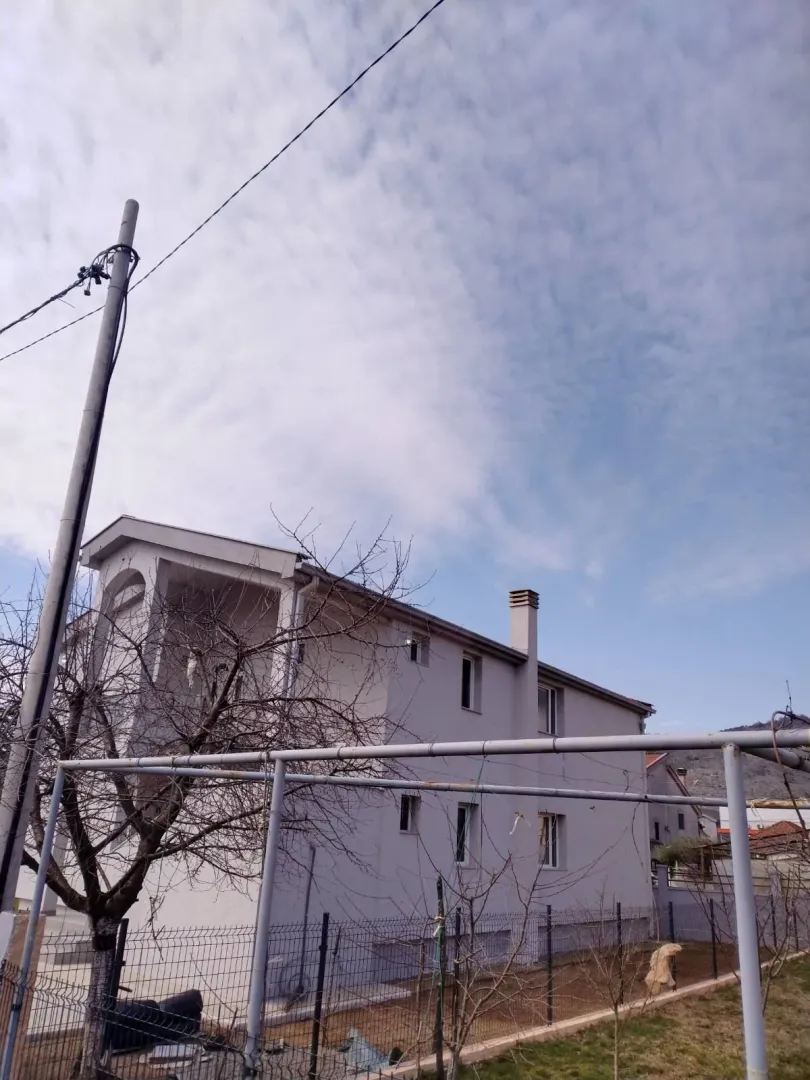 Exterior view of a two-story house with a fenced yard.