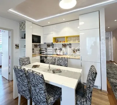 Modern kitchen with white cabinets and a dining table in the middle. - image 8