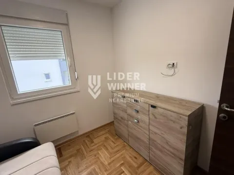 Prazna soba sa prozorom, drvenim podom i komodom. - image 3