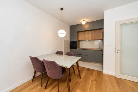 Kitchen with dining area and modern grey and wooden cabinetry. - image 2