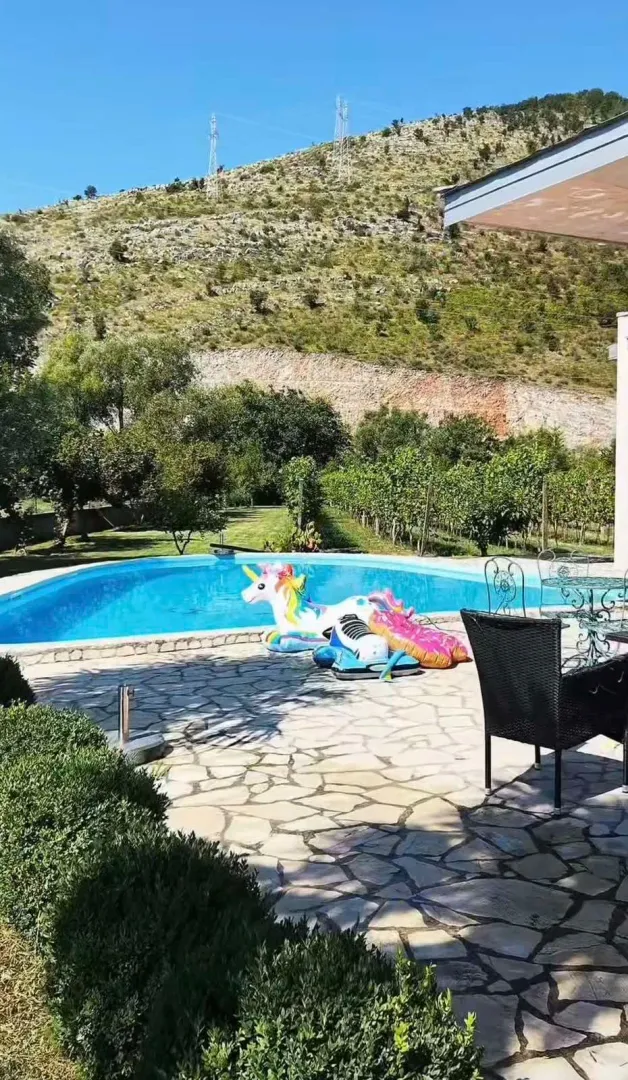 Swimming pool in the yard with a hill view.