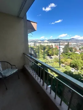 Balkon sa stolicom i pogledom na grad i planine. - image 7
