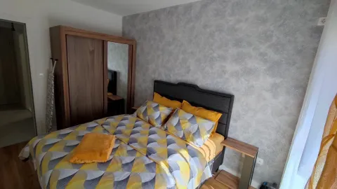 Furnished bedroom with a double bed and a wooden wardrobe. - image 6