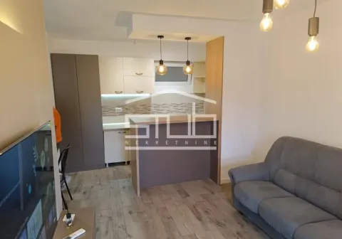 Dnevna soba sa ugaonom garniturom i pogledom na kuhinju sa šankom. - image 3
