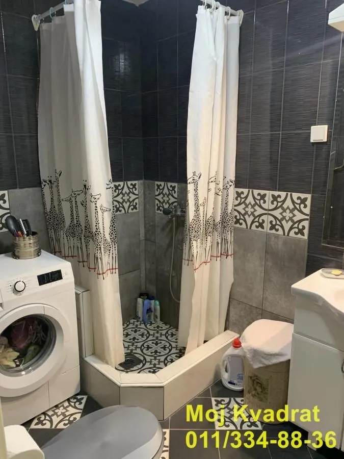 Bathroom with a shower cabin, washbasin, and washing machine.