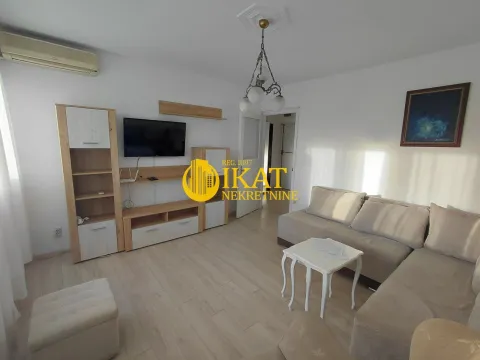 Living room with sofa, TV unit and wooden shelving. - image 12