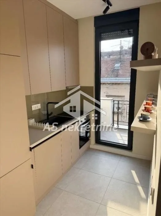 Small modern kitchen with built-in units and access to the terrace.