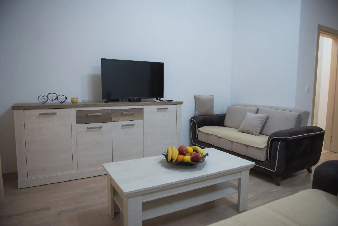 Dnevna soba sa garniturom, TV komodom i stočićem.