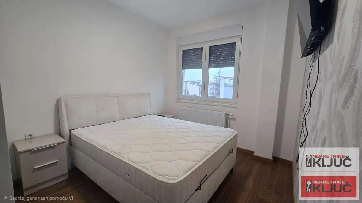Bedroom with a double bed, bedside table, and a window.