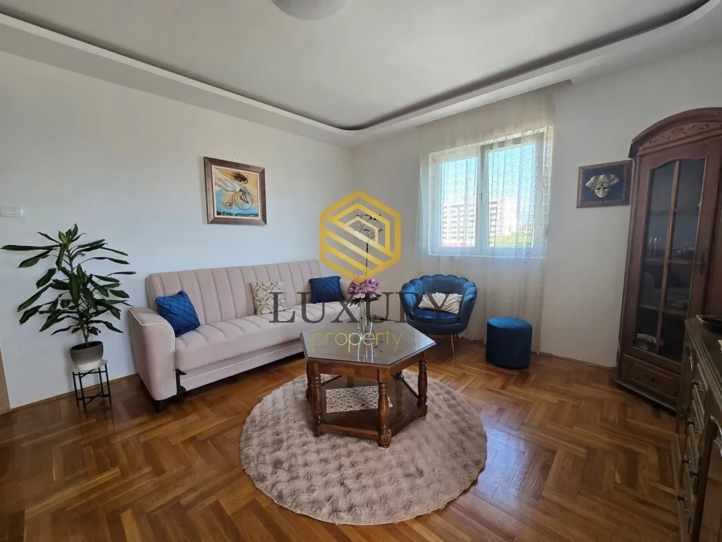 Living room with a sofa, armchair, coffee table, and wooden flooring.