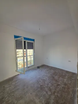 Neopremljena prostorija u izgradnji sa bijelim zidovima i balkonskim vratima. - image 5