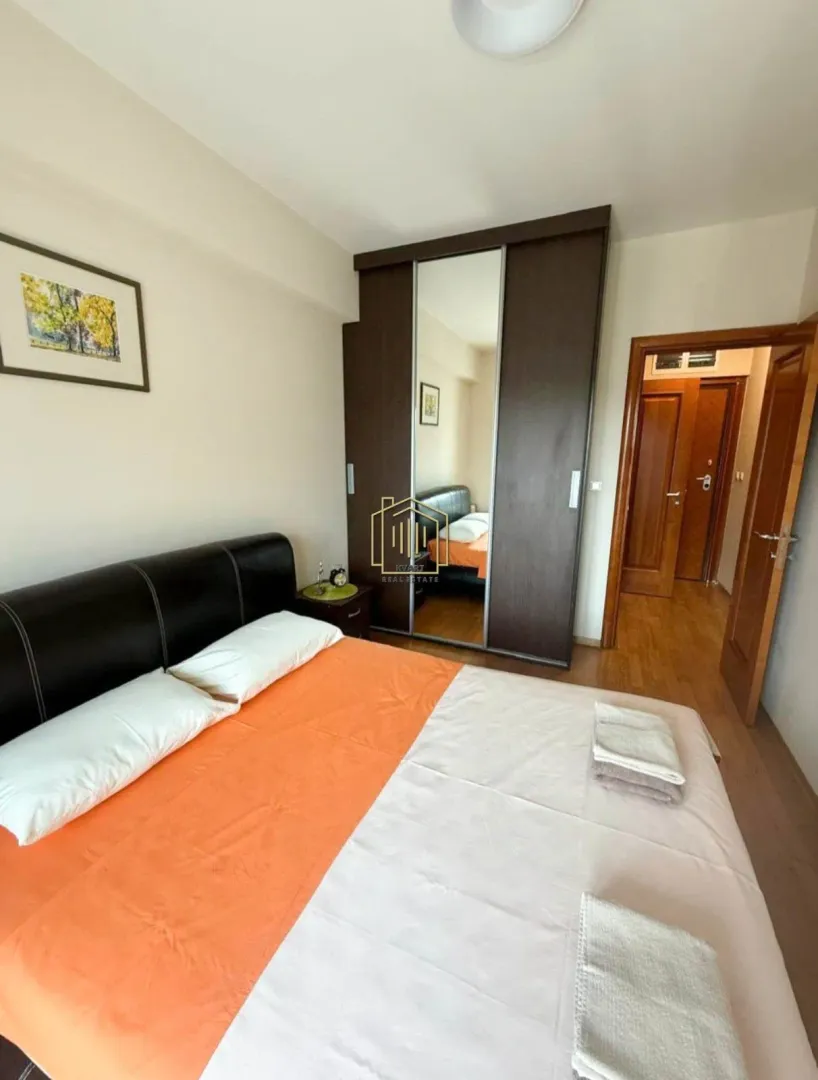 Furnished bedroom with a double bed and a wardrobe.