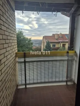 Covered balcony with a view of the surrounding neighborhood and nature. - image 2