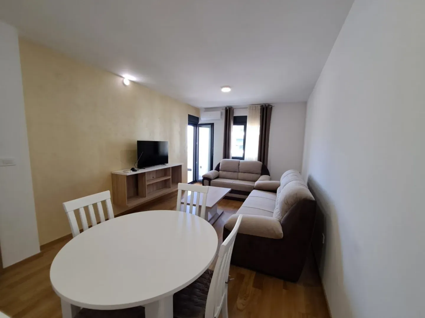 Living room with a sofa, TV, and dining table.