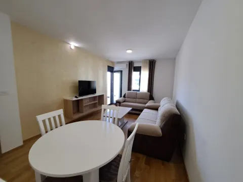 Living room with a sofa, TV, and dining table. - image 10