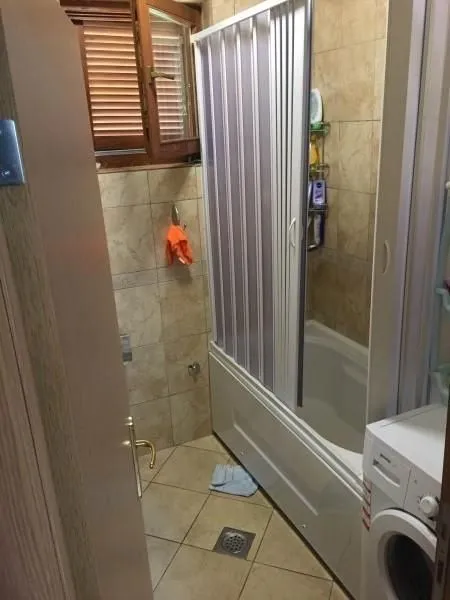 Kupatilo sa kadom, sklopivim paravanom i veš mašinom.