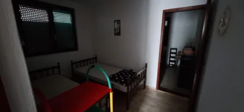 Bedroom with two single beds and a window. - image 11