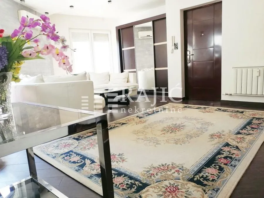 Spacious living room with sofa set and a large rug.
