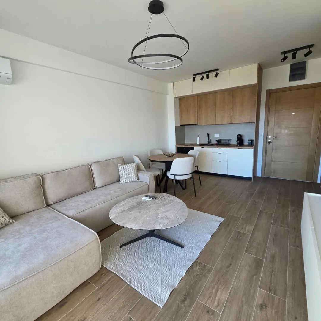 Living room with a sectional sofa, dining area, and an adjoining kitchen.