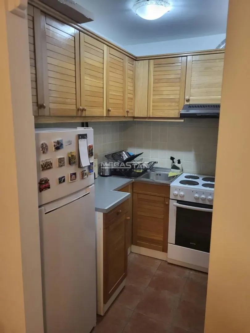 Smaller kitchen with wooden cabinets, refrigerator, and stove.