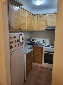 Smaller kitchen with wooden cabinets, refrigerator, and stove. - image 6