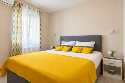 Furnished bedroom with a double bed, nightstand, and a window with curtains. - image 25