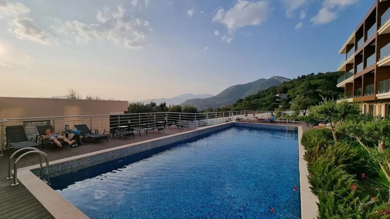 Outdoor swimming pool with sun loungers and views of the surrounding mountains.