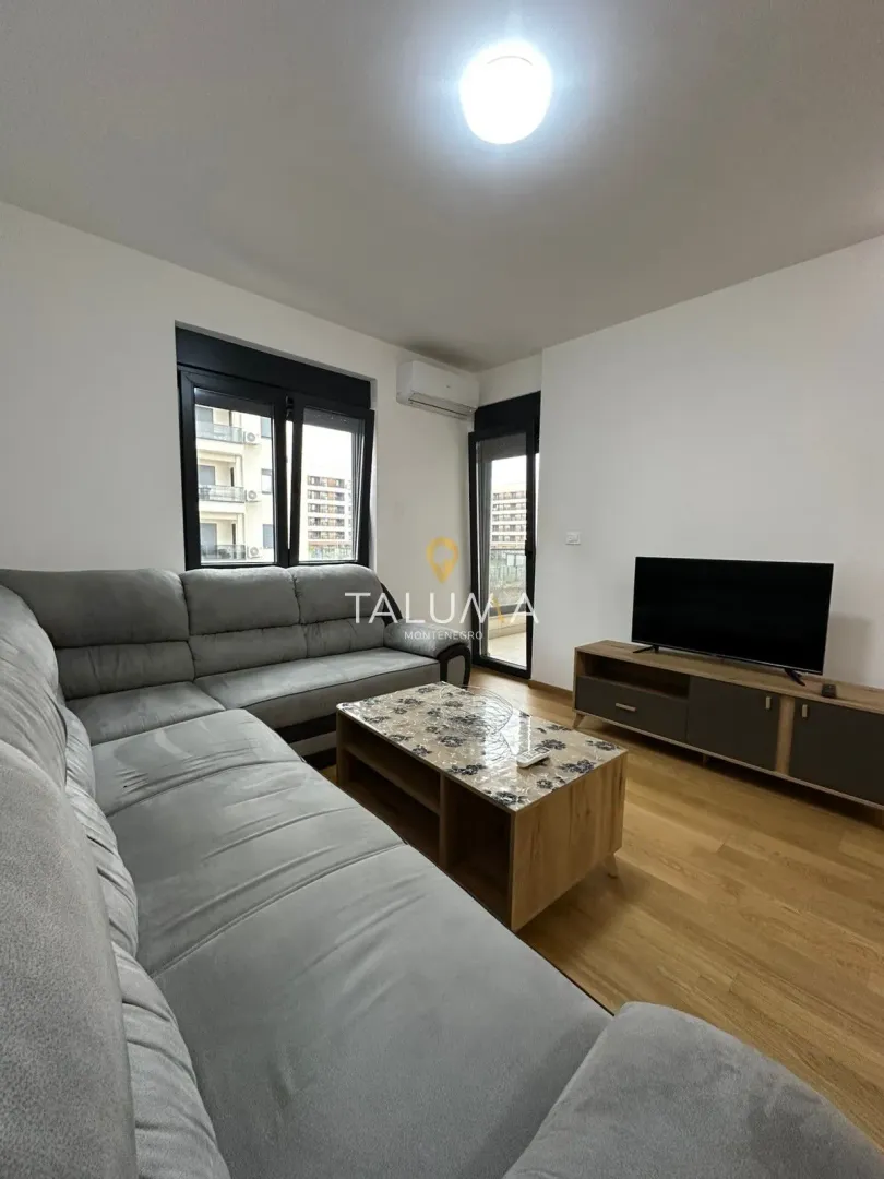Living room with a sectional sofa, coffee table, and TV unit.