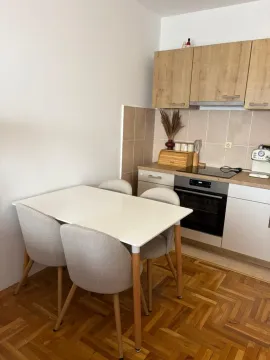 Manja kuhinja sa trpezarijskim stolom i drvenim elementima. - image 5